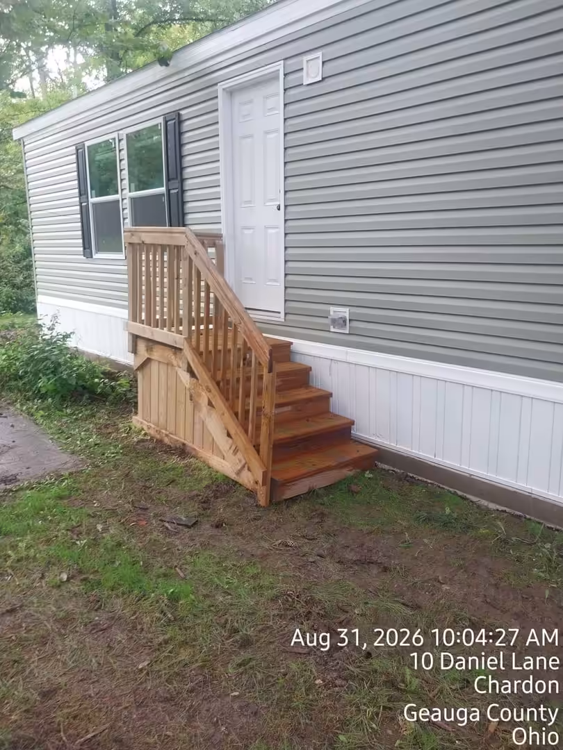 Wooden steps and railing at a mobile home door. Text: Aug 31, 2026, 10 Daniel Lane, Chardon, Ohio